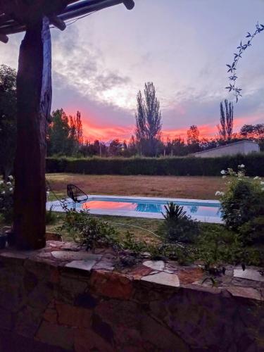 a swimming pool with a sunset in the background at El rancho de Ana in Colonia Las Rosas
