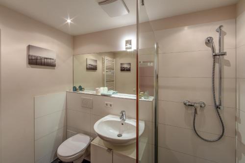 Un baño con ducha, lavabo e inodoro. en Fewo Strandliebe, en Gaienhofen