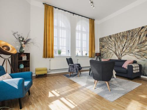 a living room with a blue couch and chairs at Altstadt-Studios Neuer Markt in Stralsund
