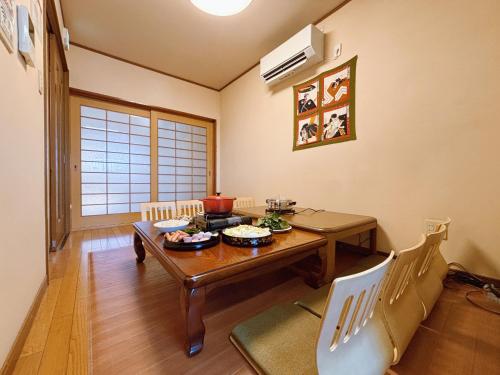 a dining room with a wooden table and a dining room at 桜の宿-大阪城Osaka castle-105m2 private-5Way access-KIX USJ 難波心斎橋 Direct in Osaka