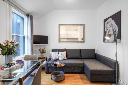 a living room with a couch and a glass table at Apt 4, Soho Apartments 2nd floor by Indigo Flats in London