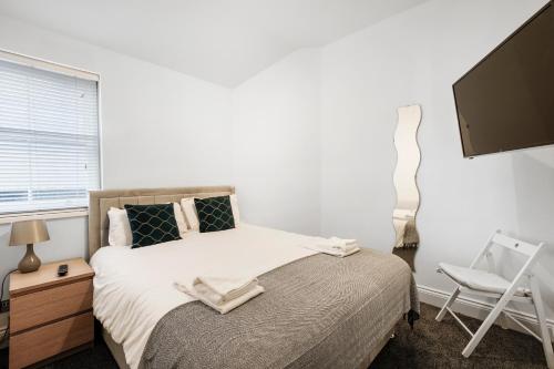 a bedroom with a bed and a tv and a chair at Apt 4, Soho Apartments 2nd floor by Indigo Flats in London