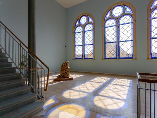 a room with a staircase and stained glass windows at Altstadt-Studios Neuer Markt in Stralsund