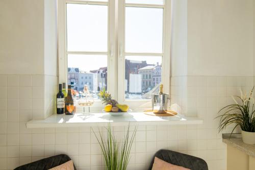 a kitchen with a window with bottles and fruit on a counter at Altstadt-Studios Neuer Markt in Stralsund