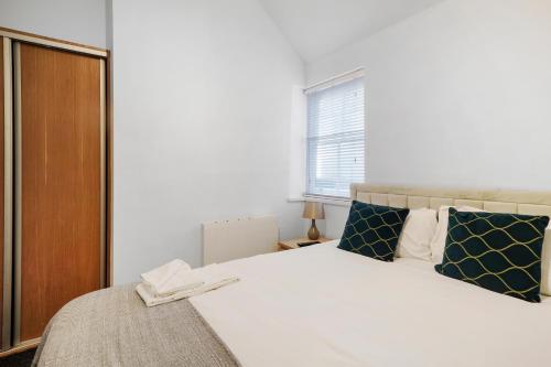 a bedroom with a large white bed with blue pillows at Apt 4, Soho Apartments 2nd floor by Indigo Flats in London