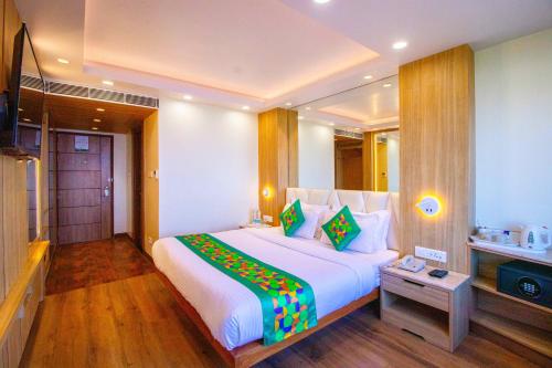 a bedroom with a large white bed with colorful pillows at Treebo Varuna With Mountain View in Shimla