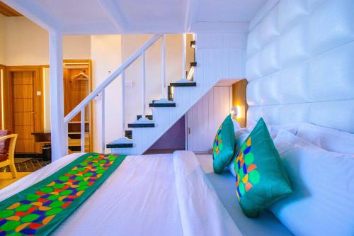 a room with a bed with pillows and a staircase at Treebo Varuna With Mountain View in Shimla