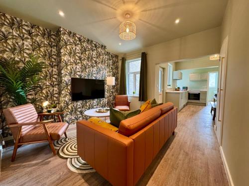 a living room with a couch and a tv at Stunning 4-Bedroom Home - 10 mins to Sandbanks Beach in Poole