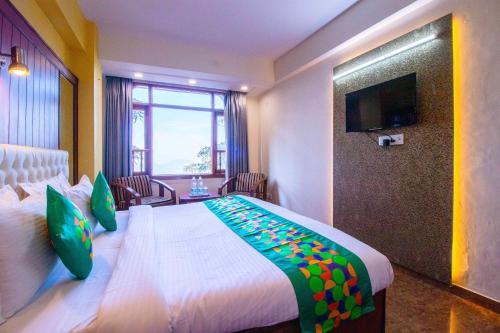 a hotel room with a large bed and a television at Treebo Varuna With Mountain View in Shimla