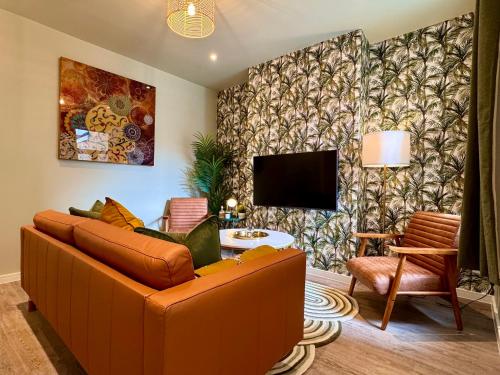 a living room with a couch and a tv at Stunning 4-Bedroom Home - 10 mins to Sandbanks Beach in Poole