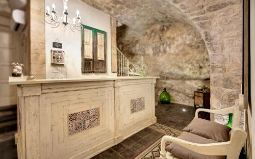 a room with a stone wall and a table and chairs at Sabbinirica in Ragusa