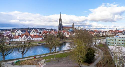 a view of a city with a river and buildings at PLAZA Premium Parkhotel Neu-Ulm in Ulm