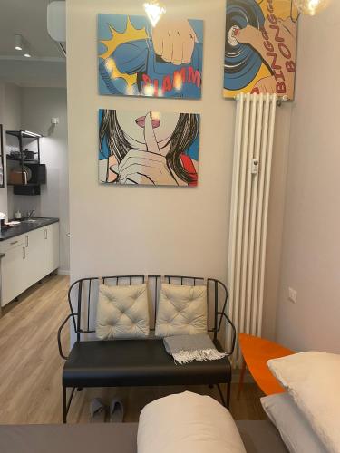 a living room with a bench and paintings on the wall at Little Milan - LM2 - LM3 - LM4 in Milan
