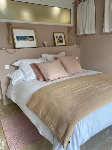 une chambre avec un grand lit avec des oreillers dessus dans l'établissement Maison proche de la plage, à Six-Fours-les-Plages