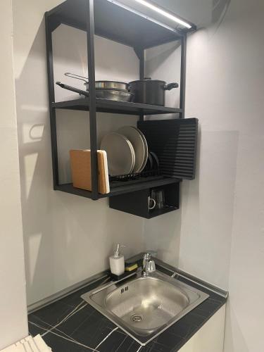 a kitchen with a sink and a shelf with pots and pans at Little Milan - LM2 - LM3 - LM4 in Milan