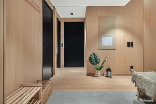 a hallway with wooden walls and a door with a potted plant at Stunning Lofoten Lodge with views and jacuzzi in Lyngværet