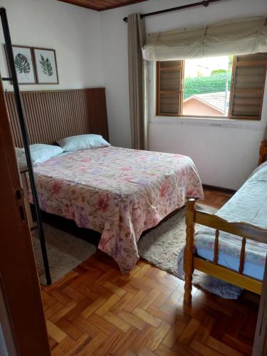 a bedroom with two beds and a window at Casa Recanto in Campos do Jordão