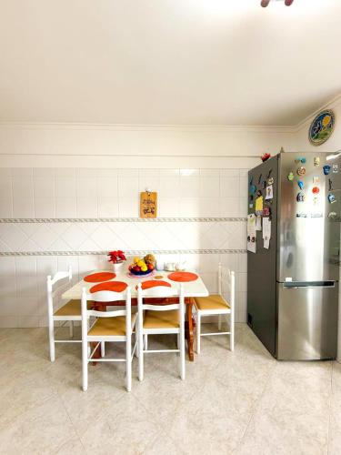 a kitchen with a white table and a refrigerator at Superhost Stay Garden View Double Room near Lisbon and Beaches in Corroios