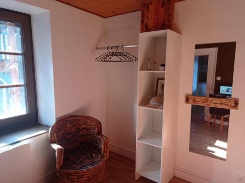 a living room with a chair and a window at Appartement cosy avec son charme ancien. in Saint-Claude