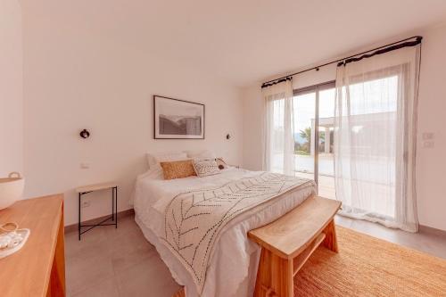 une chambre avec un grand lit et une grande fenêtre dans l'établissement Villa Loura - Villa contemporaine avec piscine, à Montfort-sur-Argens