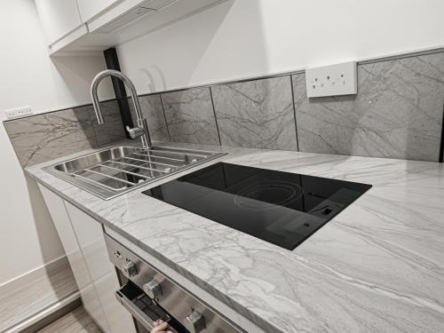 a kitchen with a sink and a counter top at Deluxe Urban Retreat Studio Apartment in London
