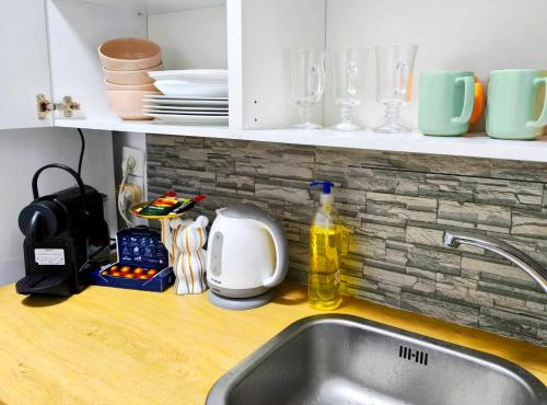 a kitchen counter with a sink and some dishes and a sink at The Sea Pearl Deganya 63 in Haifa
