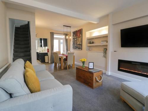 a living room with a white couch and a fireplace at Llandudno Central Townhouse in Llandudno