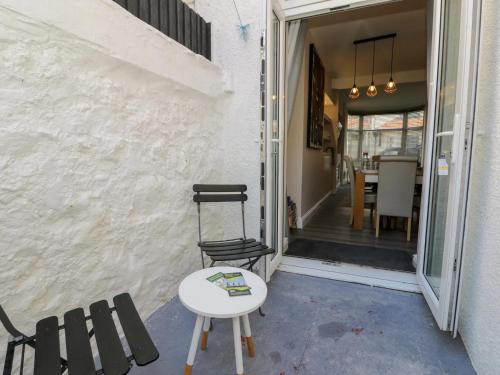 a patio with a table and chairs next to a door at Llandudno Central Townhouse in Llandudno