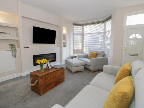 a living room with a couch and a tv at Llandudno Central Townhouse in Llandudno