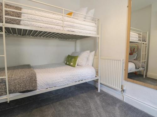 a bedroom with a bunk bed and a mirror at Llandudno Central Townhouse in Llandudno