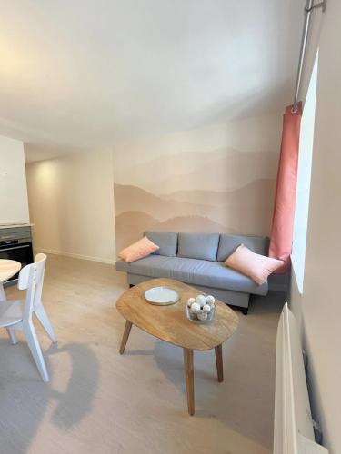 un salon avec un canapé bleu et une table dans l'établissement L'épicéa, au coeur du centre historique, à Lons-le-Saunier