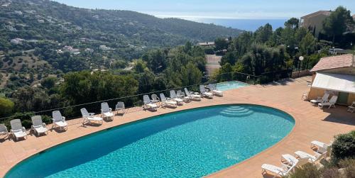 a swimming pool with lounge chairs and a view of a mountain at Loucasa Location les Issambres in Les Issambres