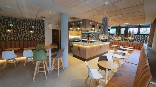 a restaurant with tables and chairs and a counter at Hotel Boutique Villa de Noreña in Noreña
