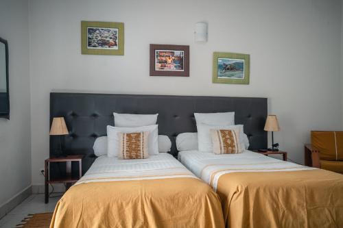 two beds sitting next to each other in a room at Relais des Plateaux & Spa– Ivato International Airport in Antananarivo