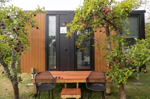 a tiny house with a wooden table and two chairs at Applewood Cabin 2 by Tiny Away in Christchurch