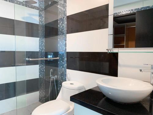 a bathroom with a toilet and a sink and a shower at Depa de lujo con piscina y jacuzzi in Guayaquil