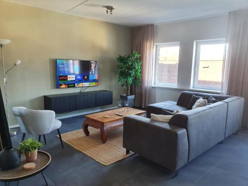a living room with a couch and a tv at Vakantiehuis centrum Lemmer in Lemmer