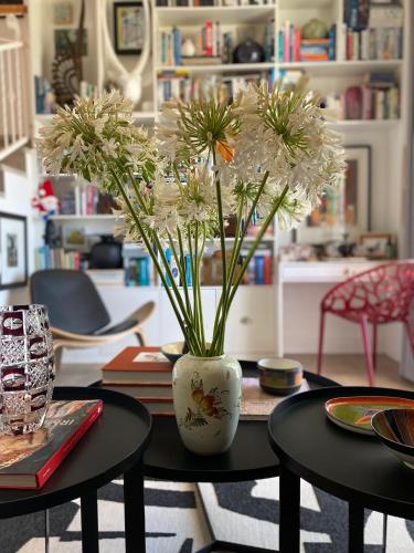 a vase with flowers on a table in a room at 1 Royal Street Guesthouse in Riebeek-Kasteel