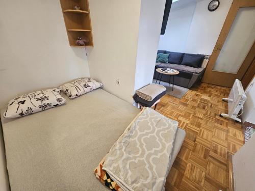 a small room with a bed and a couch at Apartman Ellye in Lukavica