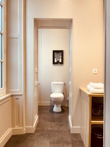 une salle de bain avec des toilettes blanches dans une chambre dans l'établissement Raconte-Moi Une Histoire, à Bayeux