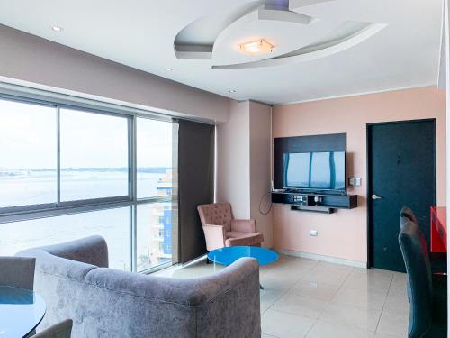 a living room with a couch and a tv at Depa de lujo con piscina y jacuzzi in Guayaquil