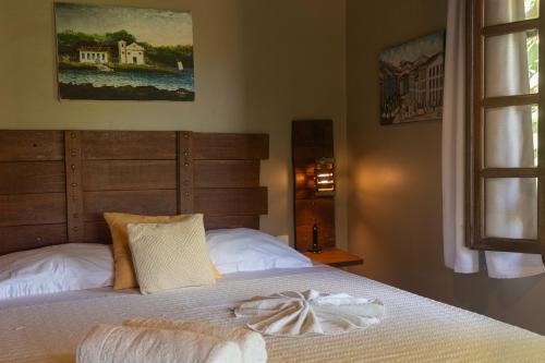 a bedroom with a bed with a blanket on it at Pousada Aquarela in Morro de São Paulo