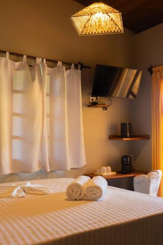 a bedroom with a bed with towels on it at Pousada Aquarela in Morro de São Paulo