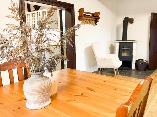 a vase sitting on a wooden table with a fireplace at Chalupa Rozálka in Cerny Dul
