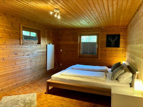 a bedroom with a bed in a wooden cabin at Blockhütte Engeln-Eifel in Kempenich