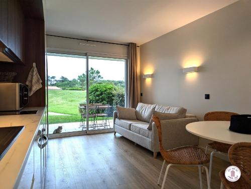 un salon avec un canapé et une table dans l'établissement Escale aux Sables, à Saint-Jean-dʼOrbetiers
