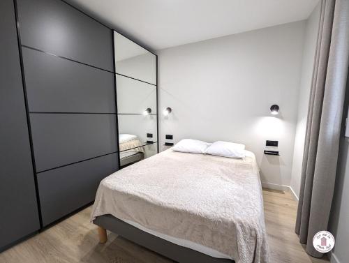 une chambre avec un lit et un grand miroir dans l'établissement Escale aux Sables, à Saint-Jean-dʼOrbetiers