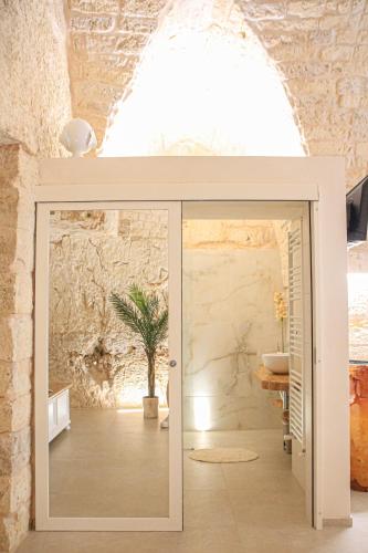a bathroom with a sliding glass door in a room at GB Grotta Bianca in Ostuni