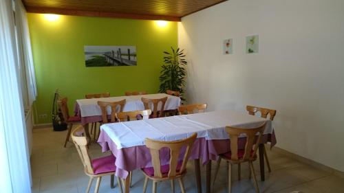 a dining room with a white table and chairs at Gästehaus Steinmetz in Sankt Martin an der Raab