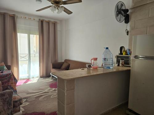 a kitchen with a counter and a living room at شالية مكيف غرفتين,ولفنج ,وحمام كامل, وتراس يرى البحر قرية بلوا لاجون 2 ليله اقل حجز عائلات فقط من فضلك in Ras Sedr